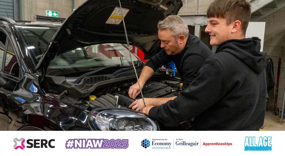 Male student and staff member working on a car engine