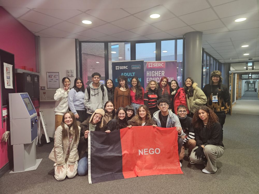 The group of visiting Brazilian students around a flag, on SERC Bangor Campus