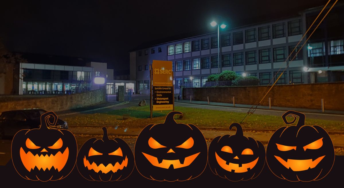 Picture of Newtownards campus at night with illustrative black pumpkins with orange eyes and mouths