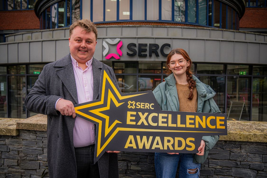 SERC Staff Member and Student holding a promotional sign for the 2025 SERC Excellence Awards