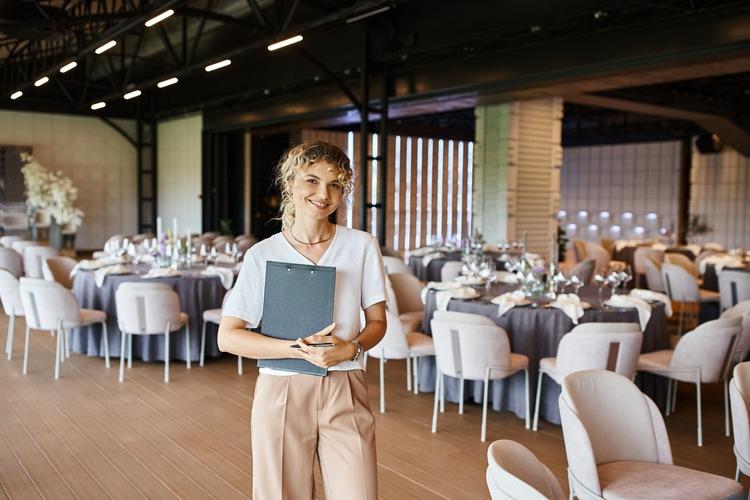 Event manager with clipboard in banquet hall