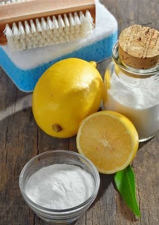 A lemon, salt and scrubber on a wooden surface 