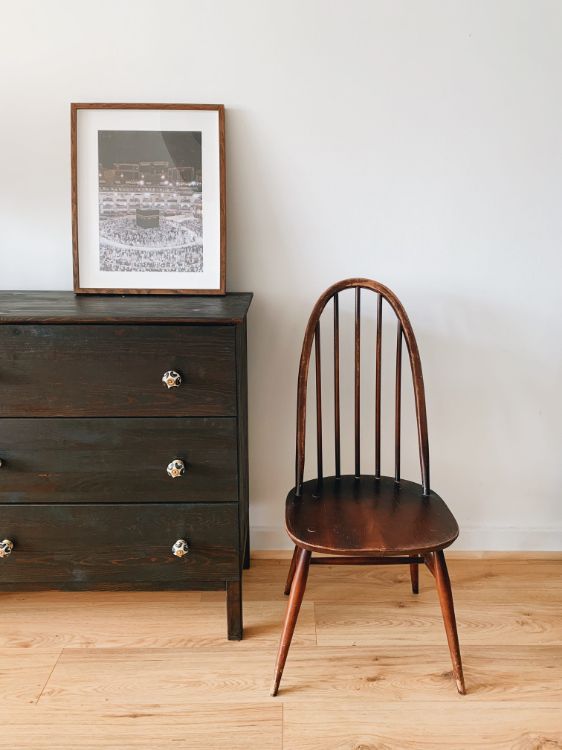 A chest of drawers, a photo frame and a chair.