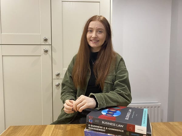 Alice Day sitting at desk with text books