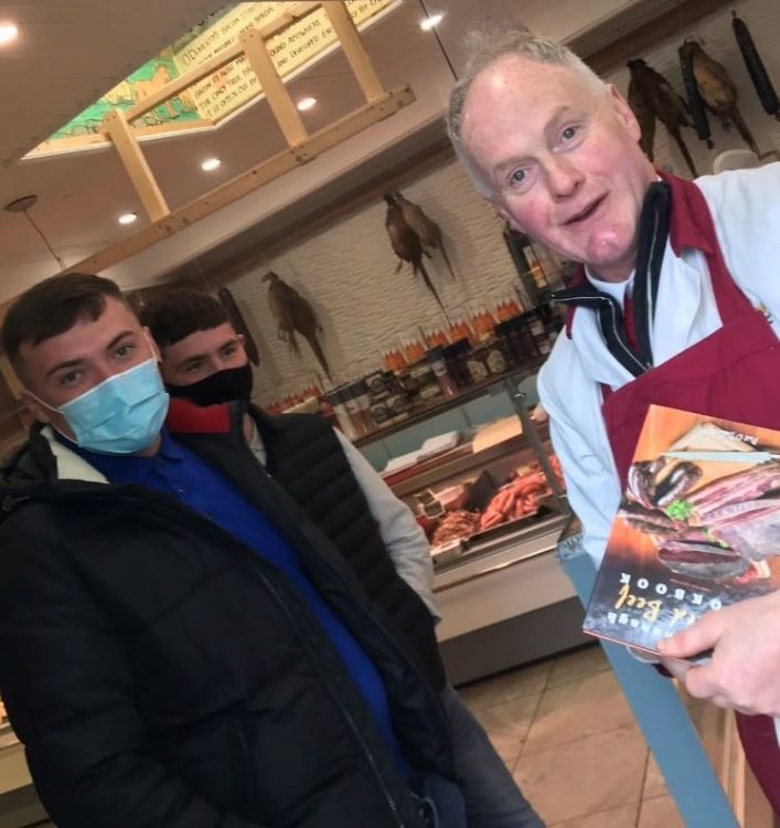 Students in butcher shop with butcher/author Pat O'Doherty