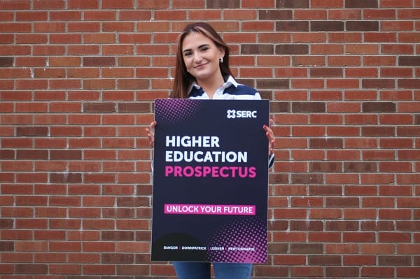 Rachel Pepper, from Dromore, a student on the HND in International Travel and Tourism Management course at Lisburn Campus. with prospectus cover promotion board.