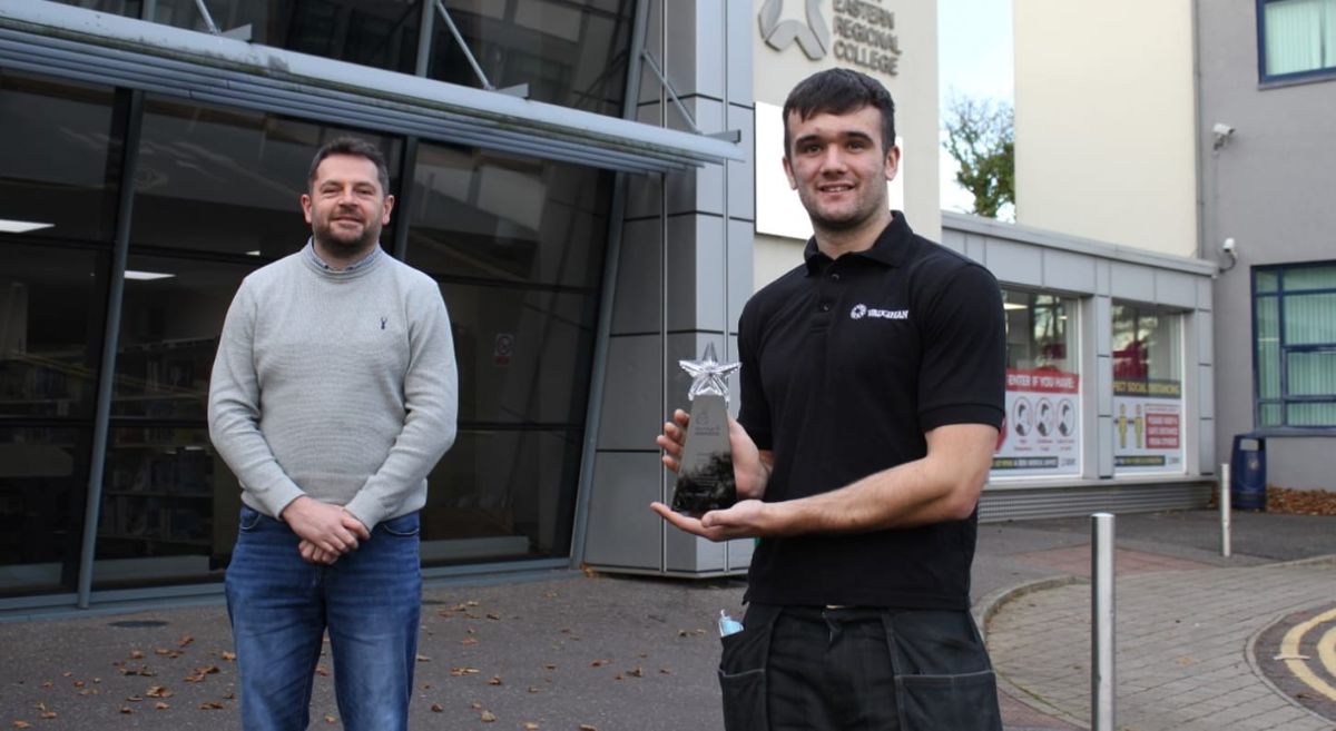 Electrical Installation lecturer John Cully  with Troy McConville holding his Award outside Newtownards Campus