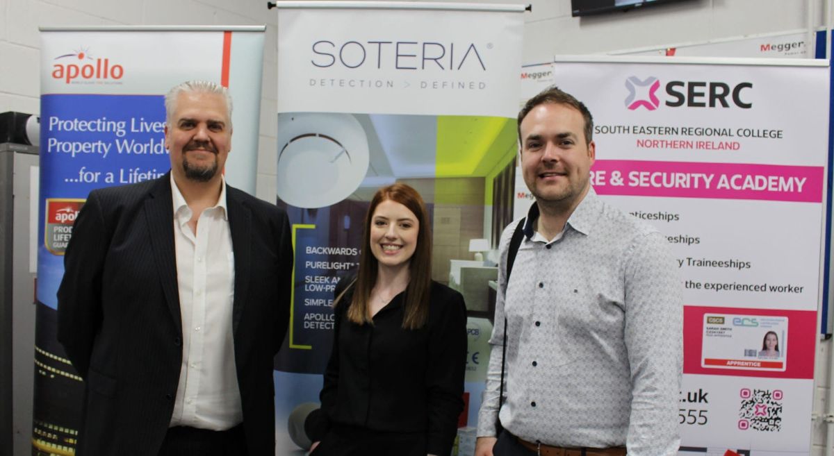 Three employers in front of display stands