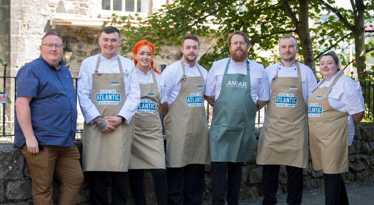 Group of Chefs in aprons pictured outside