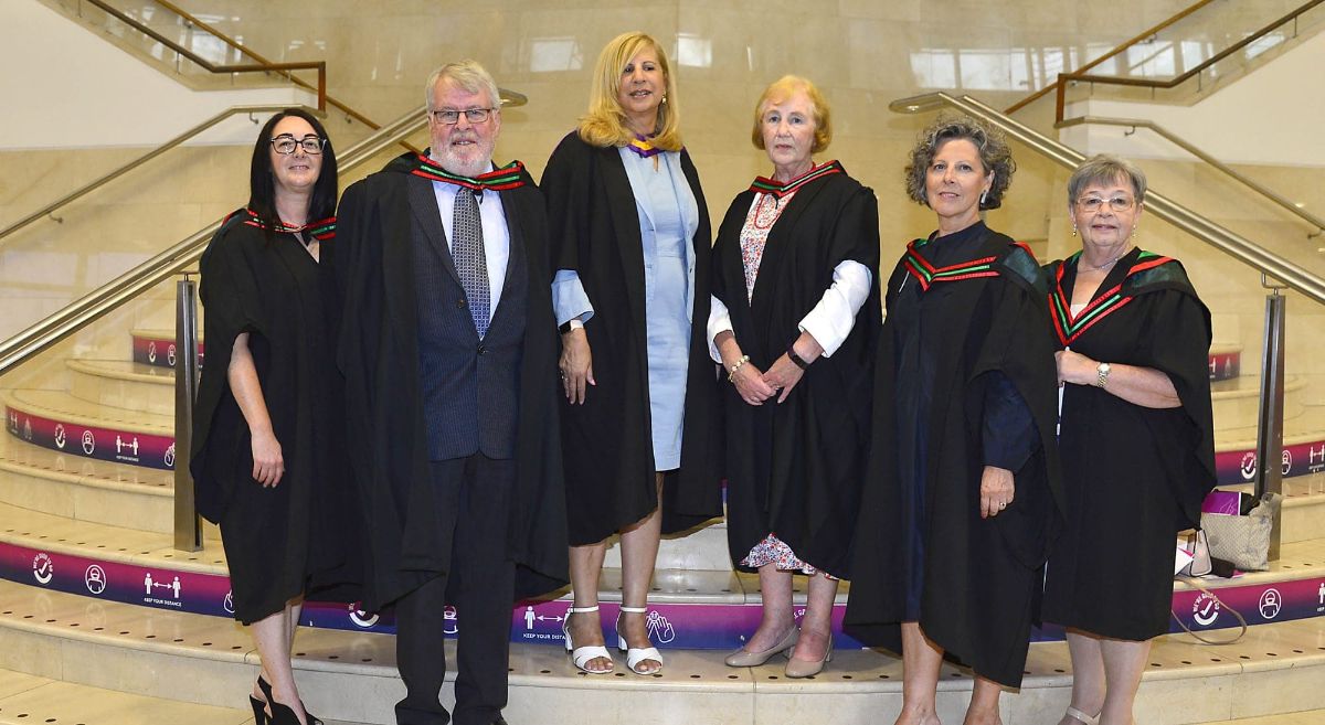 Graduates in gowns on steps