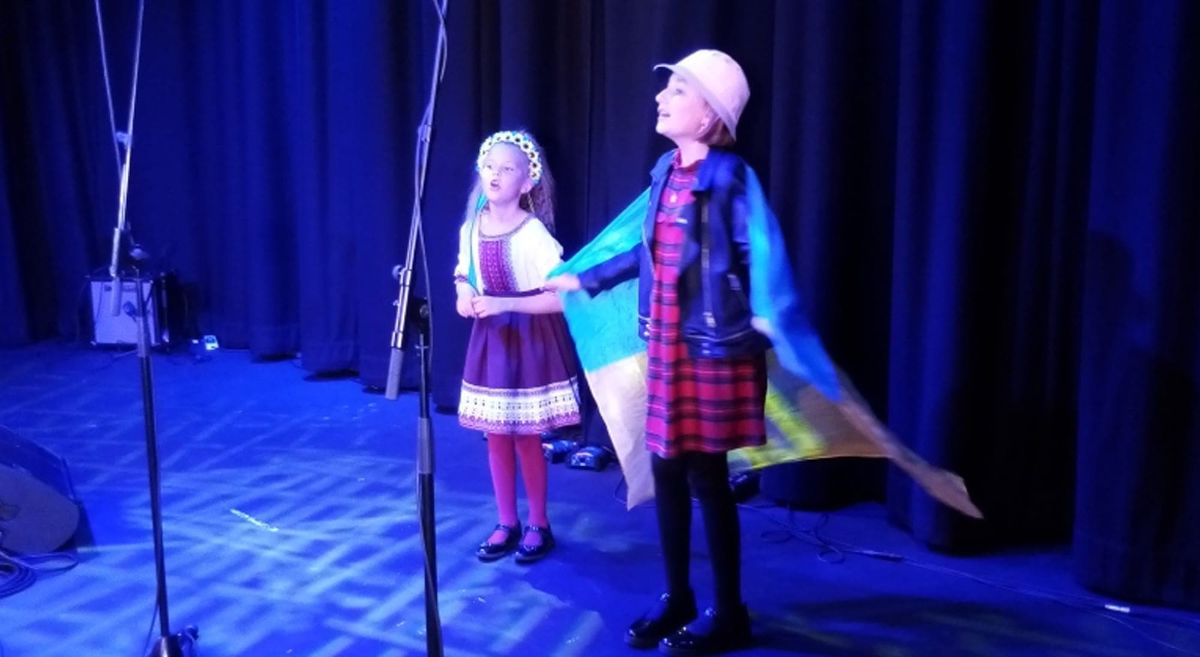 two children singing on stage