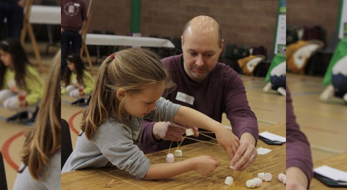 Ryan McDowell helping Thea construct a tower from spaghetti and marshmallows