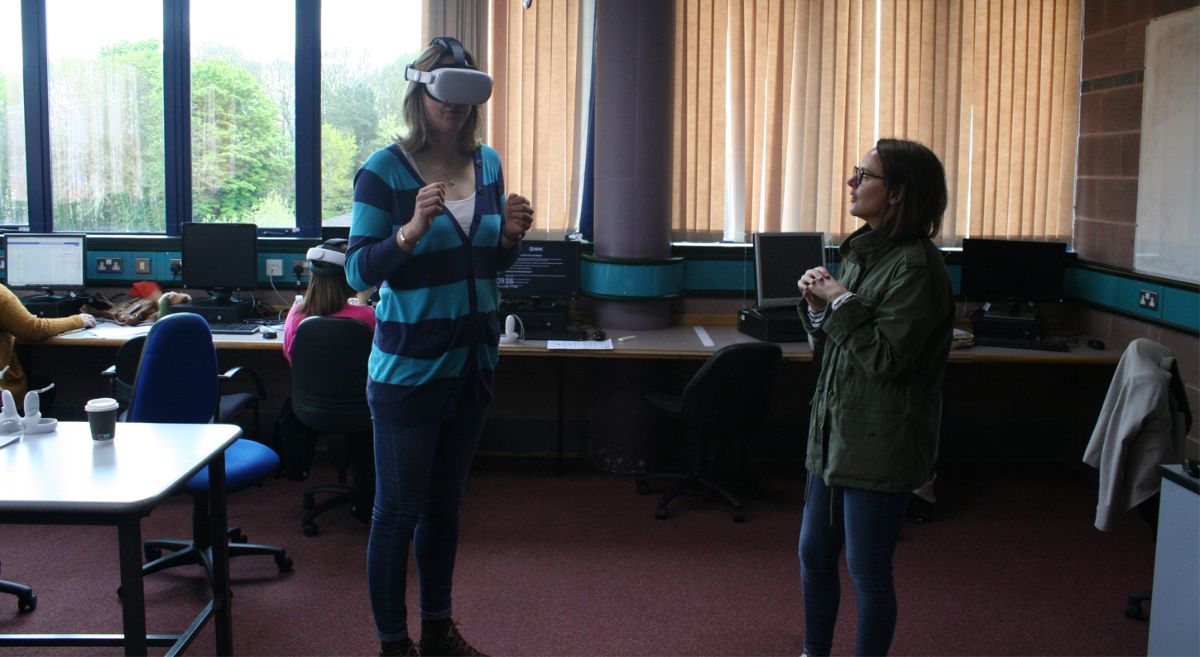 Two women standing beside each other in a classroom.