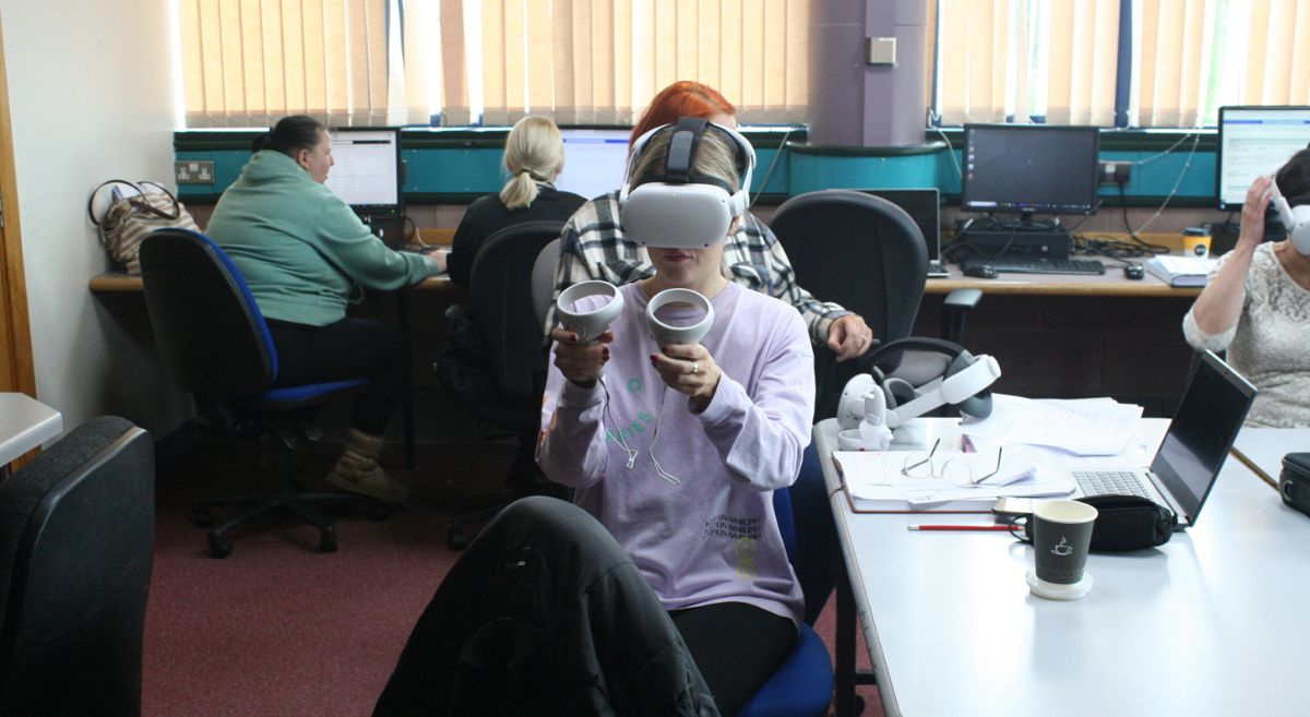 Woman wearing a VR headset and holding controllers.