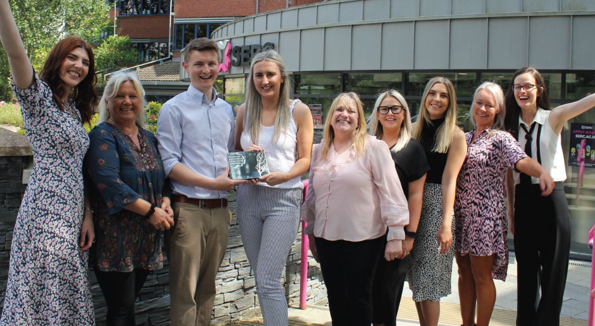 Picture of SERC Enterprise team holdingtrophy outside SERC Bangor Campus 