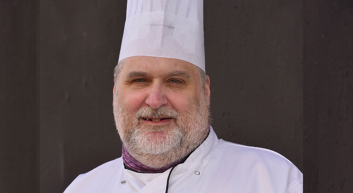 Chef Lecturer Brian Magill pictuted in chef whites against a dark background