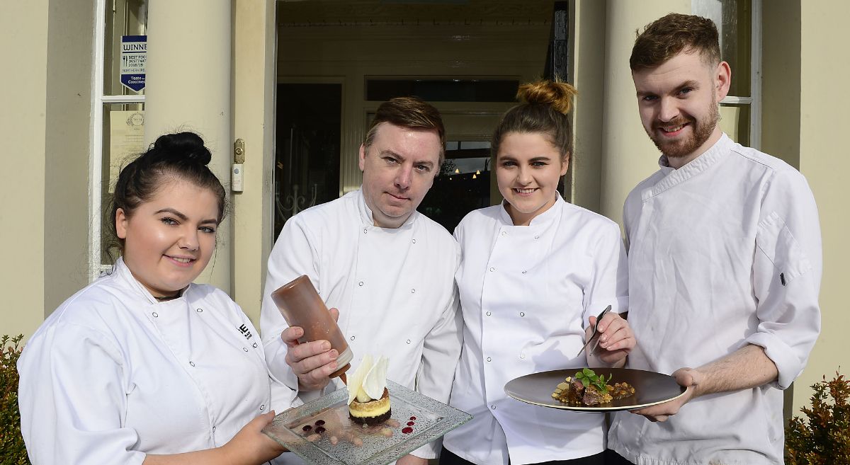 Four chefs in chef whites display dishes with food outside No 14 At the Georgian House restaurant in Comber, Co Down