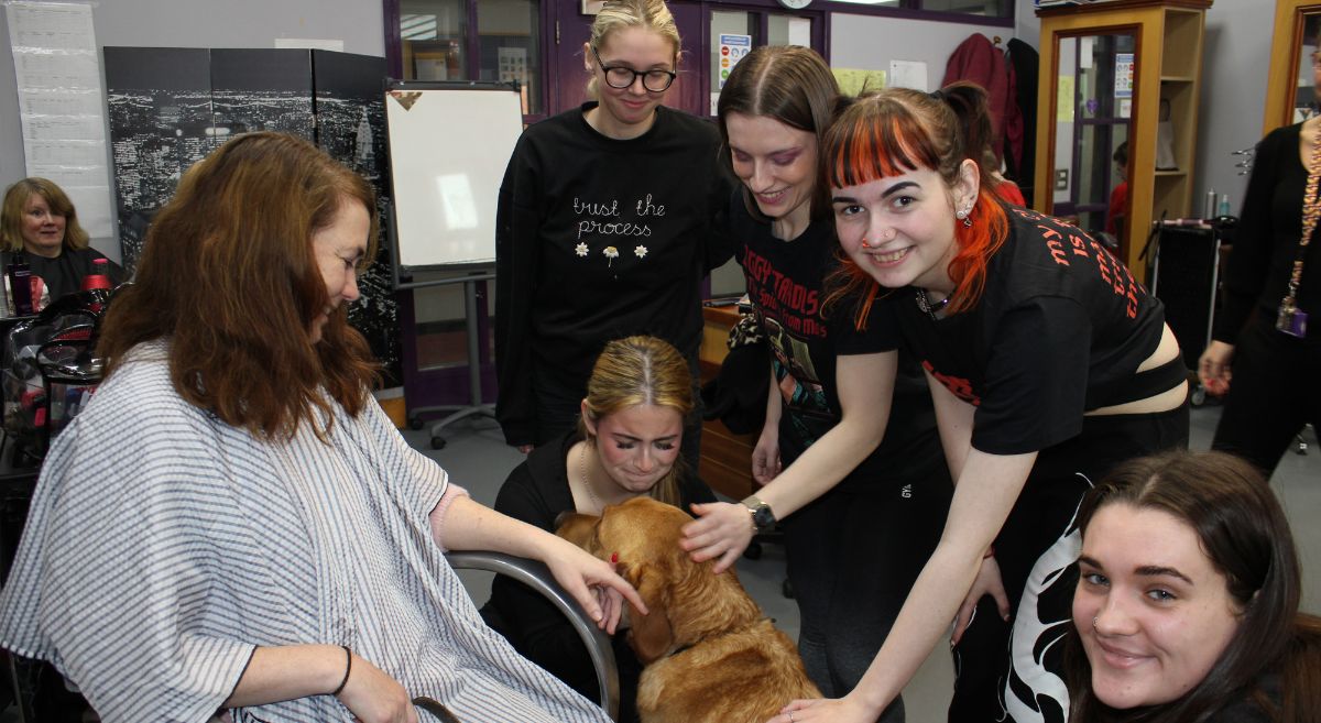 Hair and Beauty students with RNIB Client and their guide dog