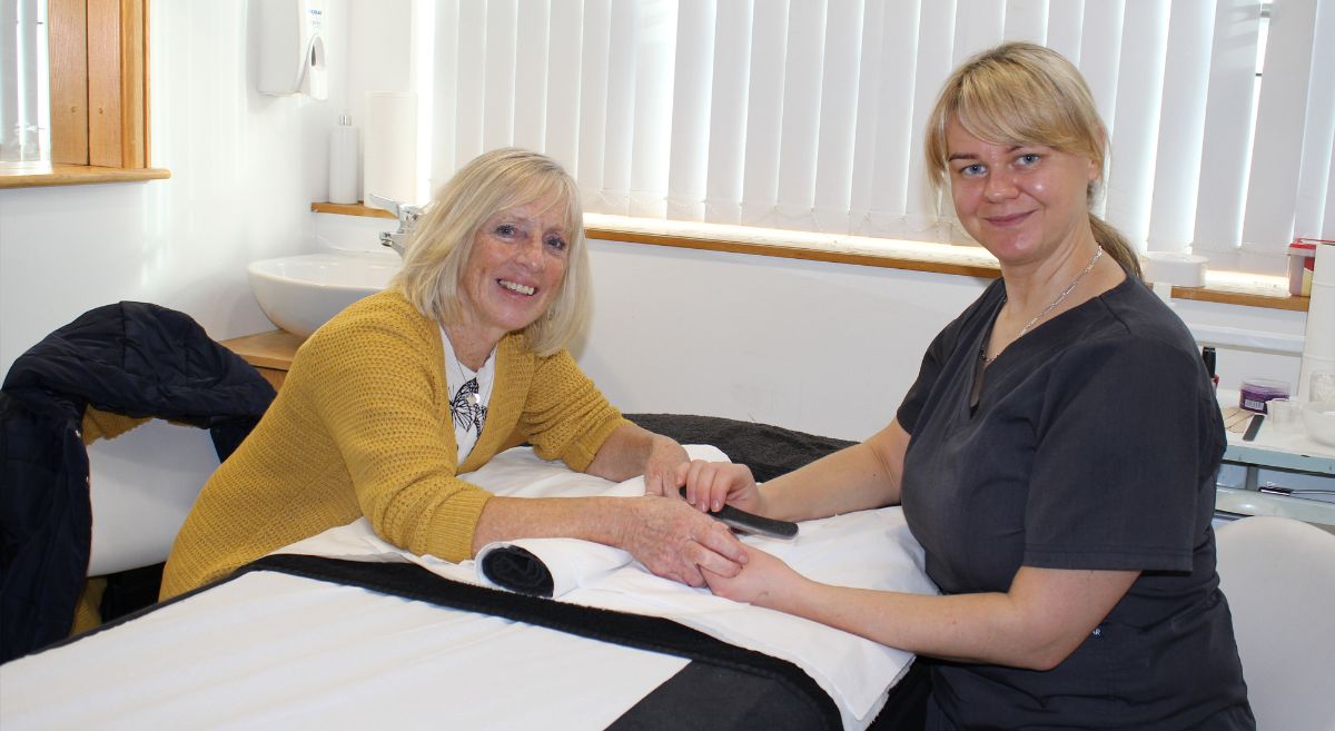 RNIB volunteer receives hand massage from student