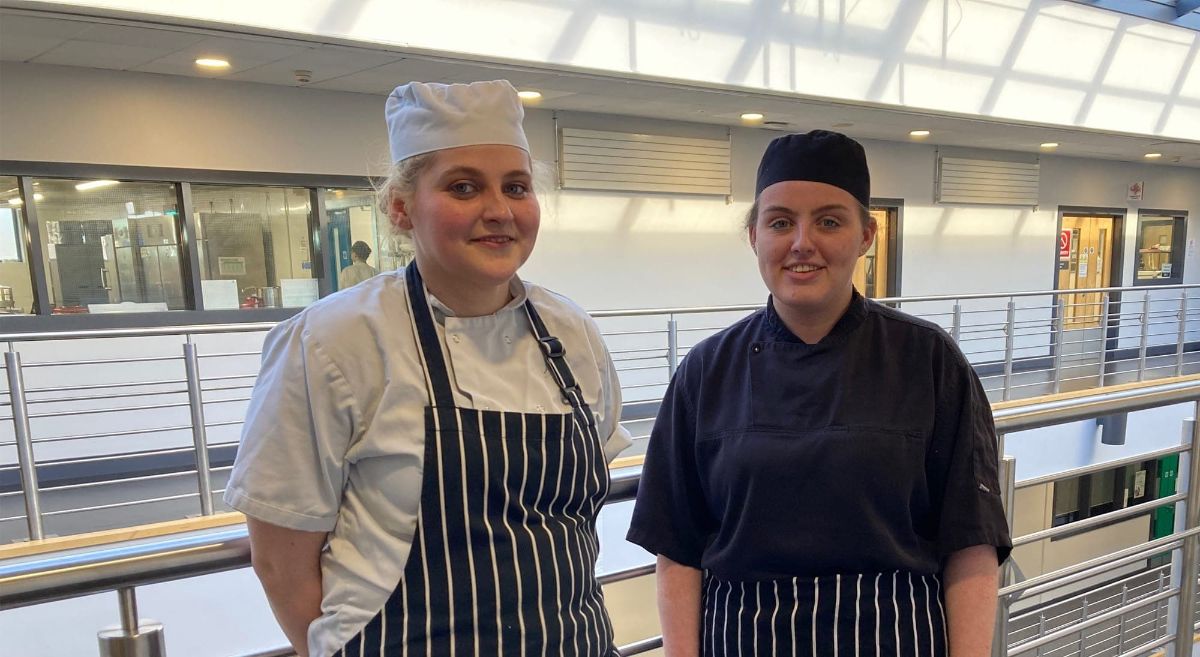 Two female culinary arts students in work wear