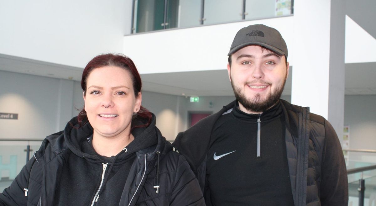 female and male culinary arts students dressed in black smiling to camera