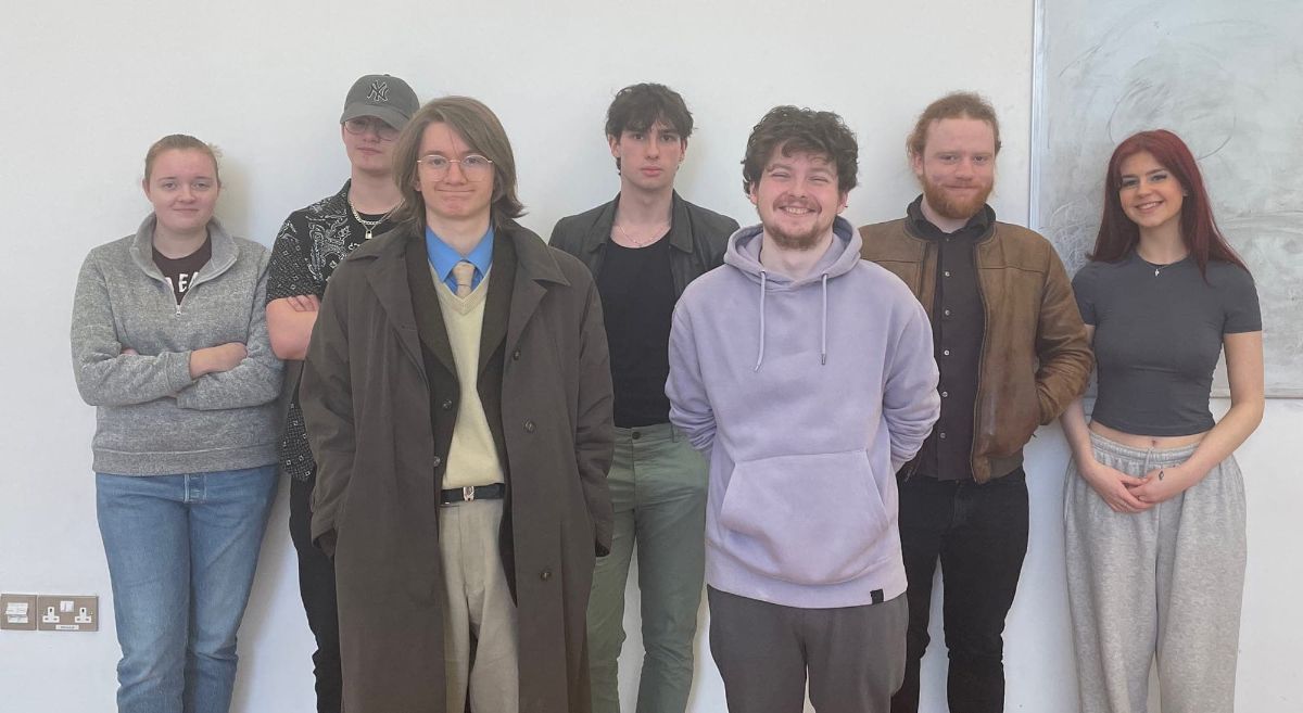 seven music students, dressed casually, standing against white background