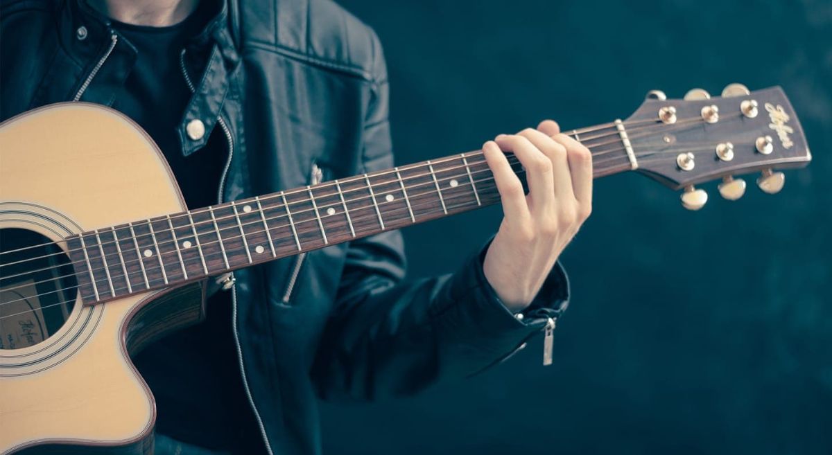 man holding acoustic guitar